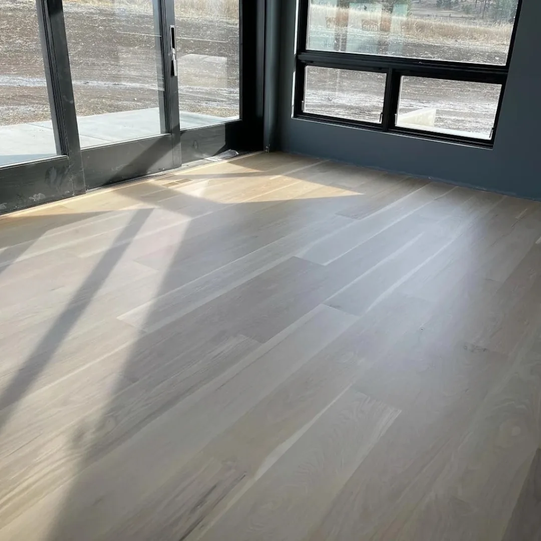 Newly installed light hardwood floor with sunlight
