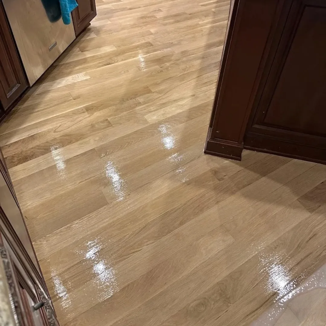 Newly refinished shiny hardwood floor in kitchen