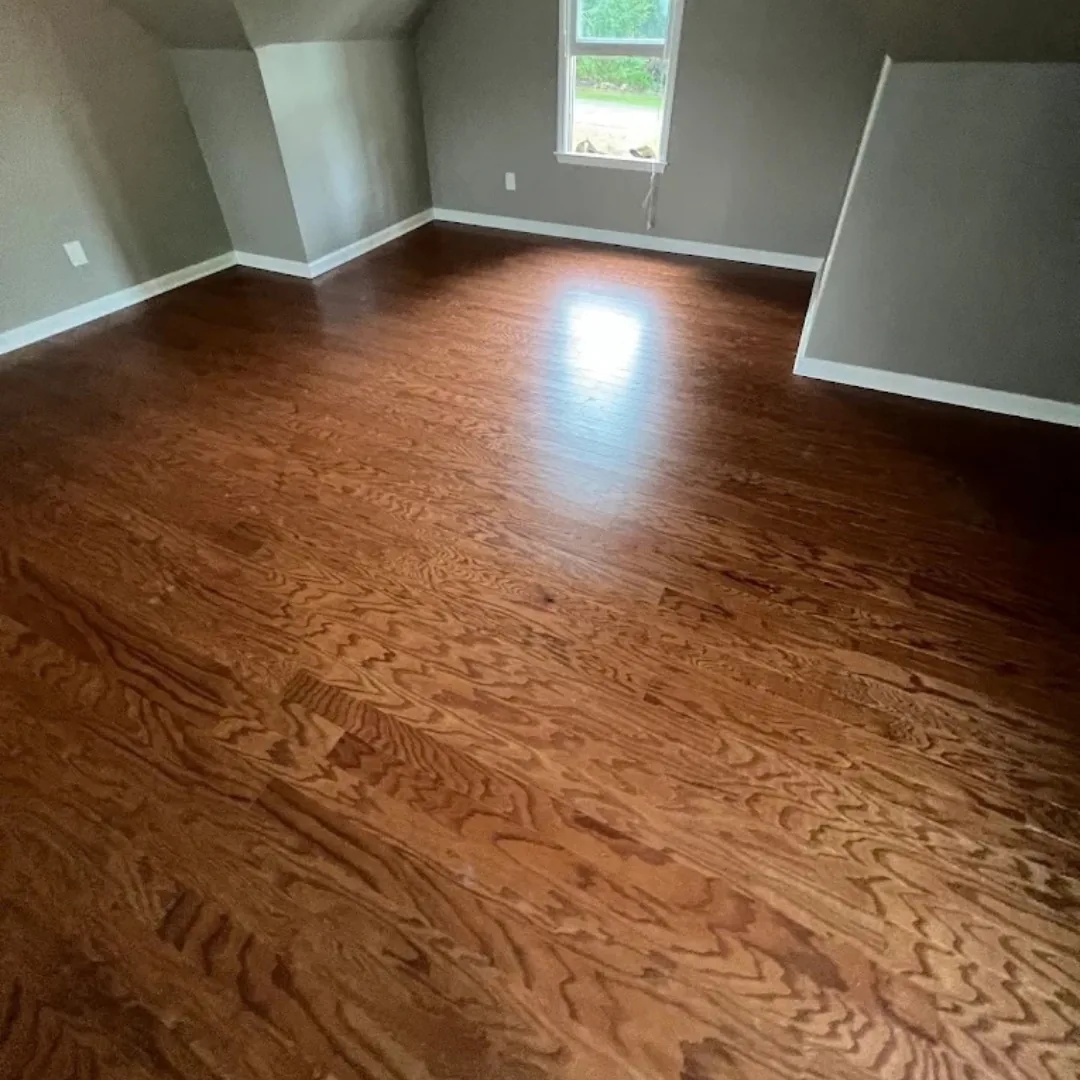 Refinished red oak hardwood flooring in empty room.