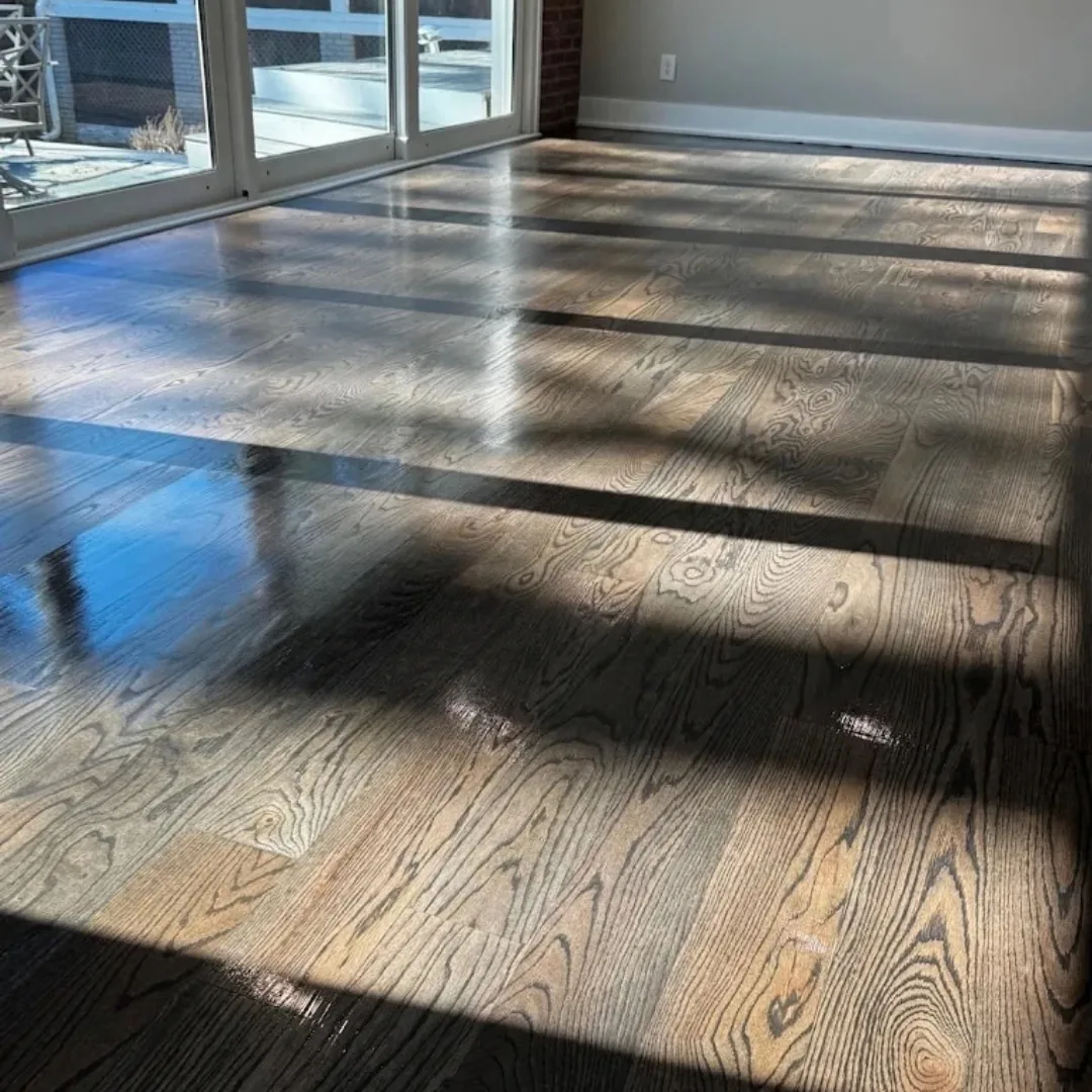 Newly refinished hardwood floor with natural light.