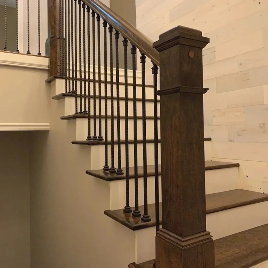 Refinished hardwood stairs with iron balusters and newel post.